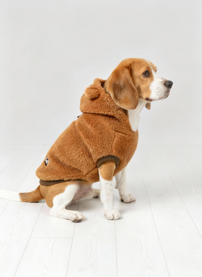 Dog wearing a brown fleece coat on a white floor