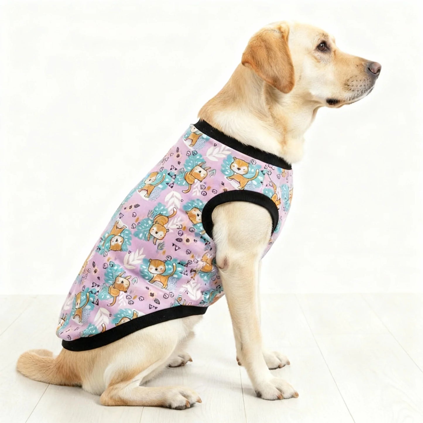 Dog wearing a colorful patterned shirt on a white floor